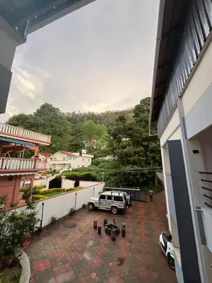 a car parked in a parking lot next to a building at Posh Holidays in Ooty