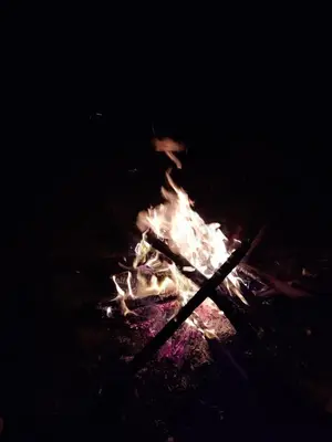 a fire in the dark with sticks in it at Posh Holidays in Ooty