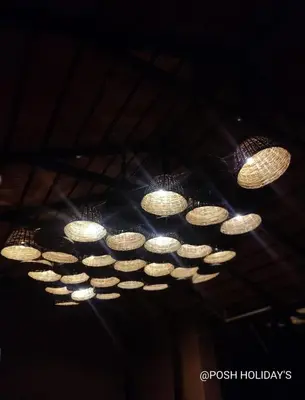 a bunch of lights hanging from a ceiling at Posh Holidays in Ooty