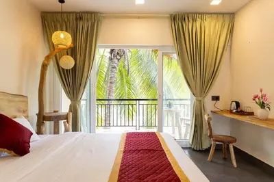 a bedroom with a bed and a large window at Coconest Premium Deluxe Rooms in Pollāchi