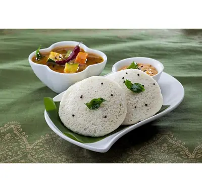 three plates of food on a table with bowls of soup at Coconest Premium Deluxe Rooms in Pollāchi