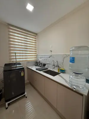 a kitchen with a sink and a water container on the counter at Dwaraka-Serene Riverfront 2BHK in Palakkad
