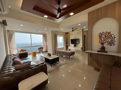 a large living room with a couch and a tv at Dwaraka-Serene Riverfront 2BHK in Palakkad