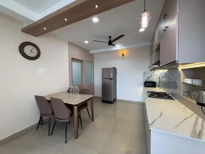 a kitchen with a table and chairs and a refrigerator at Dwaraka-Serene Riverfront 2BHK in Palakkad
