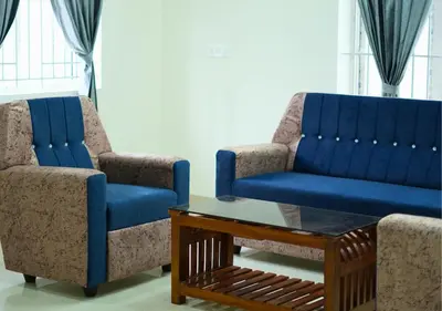 two blue chairs and a coffee table in a room at Village Homestays By Adrta Groups in Marudhamalai