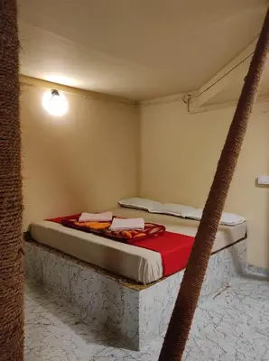a bedroom with a bed with a red blanket at Ponkunnu Farmstay and Resorts - Emerald - The Tree House - Ground Floor in Bālūssheri