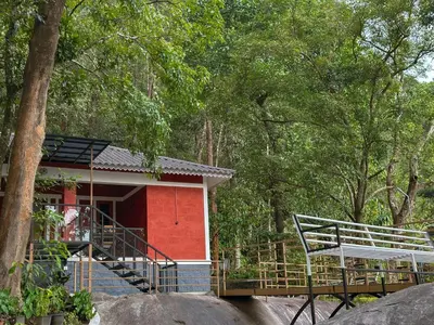 a red house with a staircase leading to it at Rockviewstay in Kalpetta