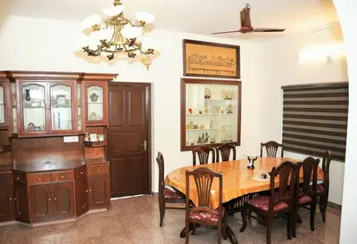 a dining room with a wooden table and chairs at White Haven in Angamali
