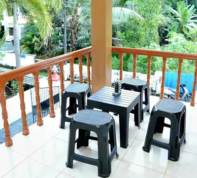 a patio with four chairs and a table on a balcony at White Haven in Angamali
