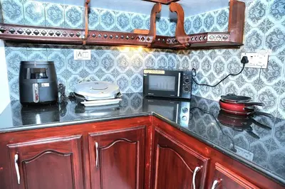 a kitchen with a counter with a microwave and a coffee maker at White Haven in Angamali