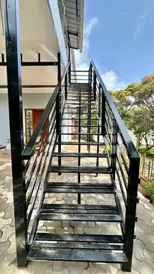 a metal staircase leading up to a house at Cloud Crest Homestay in Ooty