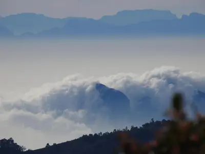 a mountain covered in a layer of clouds at Cloud Crest Homestay in Ooty
