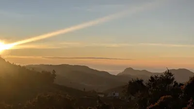a view of the sun setting over the mountains at Cloud Crest Homestay in Ooty