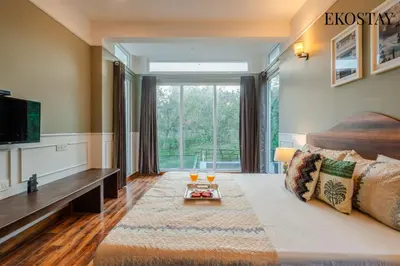 a bedroom with a large bed and a large window at EKOSTAY - Echo Villa in Kodaikānāl