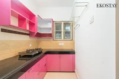 a kitchen with pink cabinets and a stove at EKOSTAY - Echo Villa in Kodaikānāl