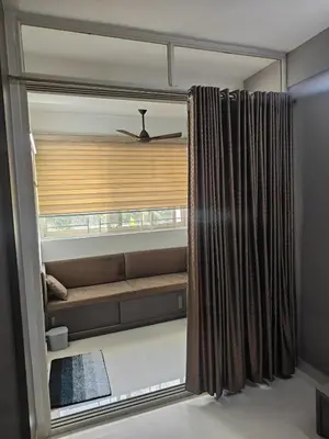 a room with a window with a couch and a curtain at Aapt green field in Trichūr