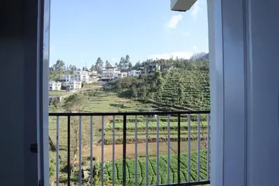 a view from a window of a hill with houses at Kerith in Kodaikānāl