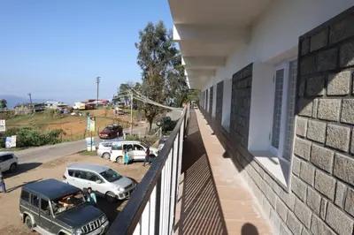 a balcony of a building with cars parked in a parking lot at Kerith in Kodaikānāl