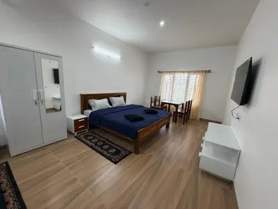 a bedroom with a bed and a table and a tv at Kerith in Kodaikānāl