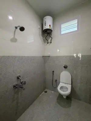 a bathroom with a white toilet and a window at Kerith in Kodaikānāl