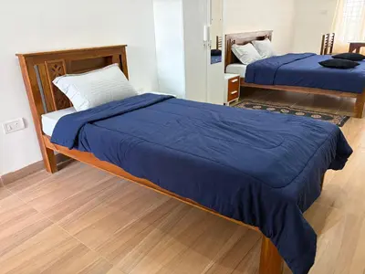 a bedroom with two beds with blue sheets on them at Kerith in Kodaikānāl