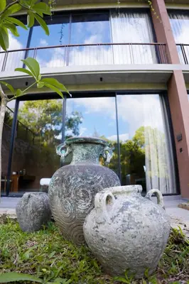 a large vase sitting in the grass in front of a building at Ayana Villa By KPM in Varagampadi