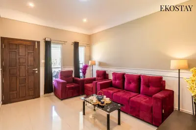 a living room with a red couch and two chairs at EKOSTAY - Helios Villa in Kodaikānāl