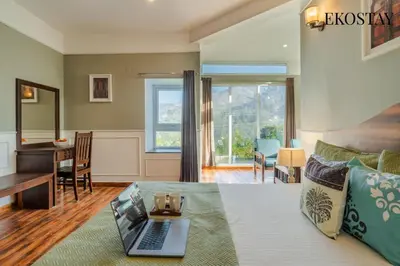 a living room with a laptop on a couch at EKOSTAY - Helios Villa in Kodaikānāl
