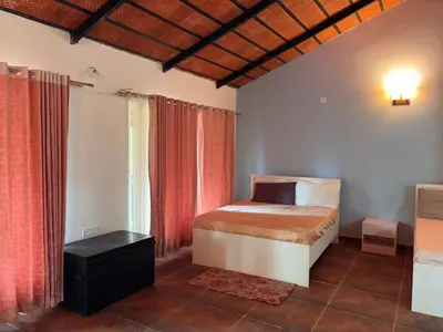 a bedroom with a bed and a window at Paddy Creek Jungle Resort Coorg in Virajpet