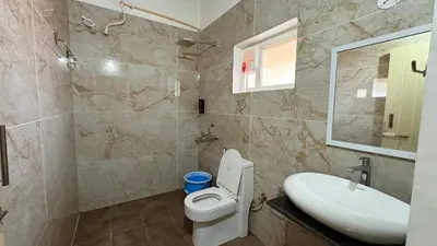 a bathroom with a toilet and a sink and a mirror at Paddy Creek Jungle Resort Coorg in Virajpet