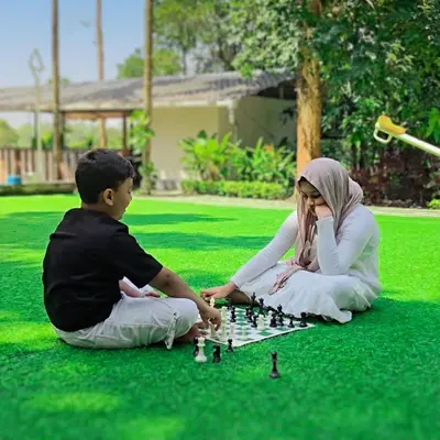 a man and a woman playing chess on the grass at Nellar Dream Resort in Meppādi