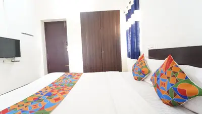a bedroom with a white bed with colorful pillows at H N Residency in Coimbatore
