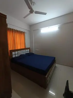 a bed in a room with a ceiling fan at 1bhk Kalp Guruvayur 150m to temple in Trichūr