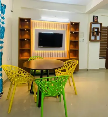 a dining room with a table and chairs and a tv at Apartment in Guruvayur- Sooryamadhavam-only for families in Guruvāyūr