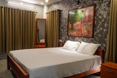 a bedroom with a bed and a painting on the wall at Vista Chembra Service Apartment 20B in Meppādi