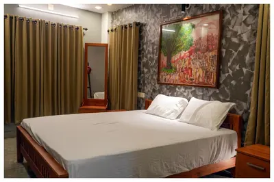 a bedroom with a bed and a painting on the wall at Vista Chembra Service Apartment 20B in Meppādi