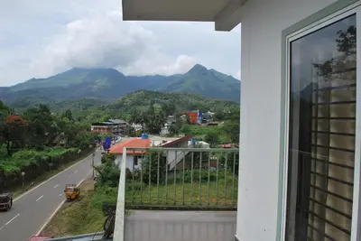 a balcony with a view of a road and mountains at Vista Chembra Service Apartment 20B in Meppādi