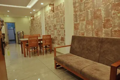 a restaurant with a couch and a table and chairs at Vista Chembra Service Apartment 20B in Meppādi