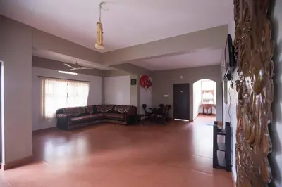 a living room with a couch and a table at Tapovan Fruitopia in Sultan Bathery