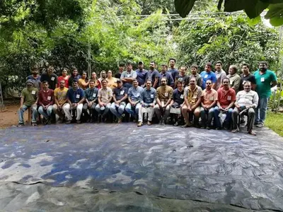 a group of people posing for a picture on a rock at Tapovan Fruitopia in Sultan Bathery