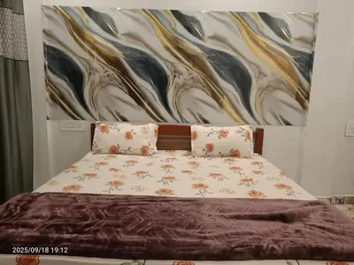 a bedroom with a bed with a painting on the wall at Darby Homestay in Kanthalloor