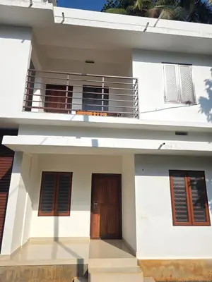 a white house with two doors and a balcony at Paithal haven in Paithalmala