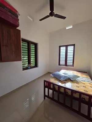 a bedroom with a bed and a ceiling fan at Paithal haven in Paithalmala