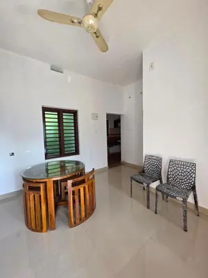 a dining room with a glass table and two chairs at Paithal haven in Paithalmala