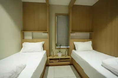 two beds in a room with white pillows at Rasha Suites in Kalpetta