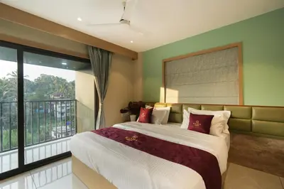 a bedroom with a large bed and a balcony at Rasha Suites in Kalpetta