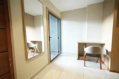 a room with a mirror and a chair and a desk at Rasha Suites in Kalpetta