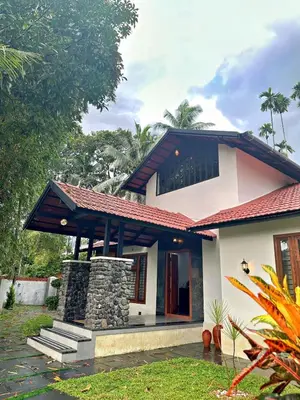 a small house with a red roof at Bougainvilla in Kozhikode