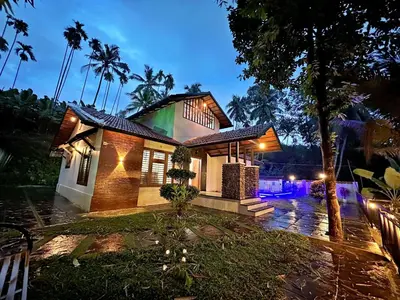 a house with lights in front of it at night at Bougainvilla in Kozhikode