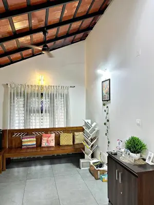 a living room with a bench and a window at Bougainvilla in Kozhikode